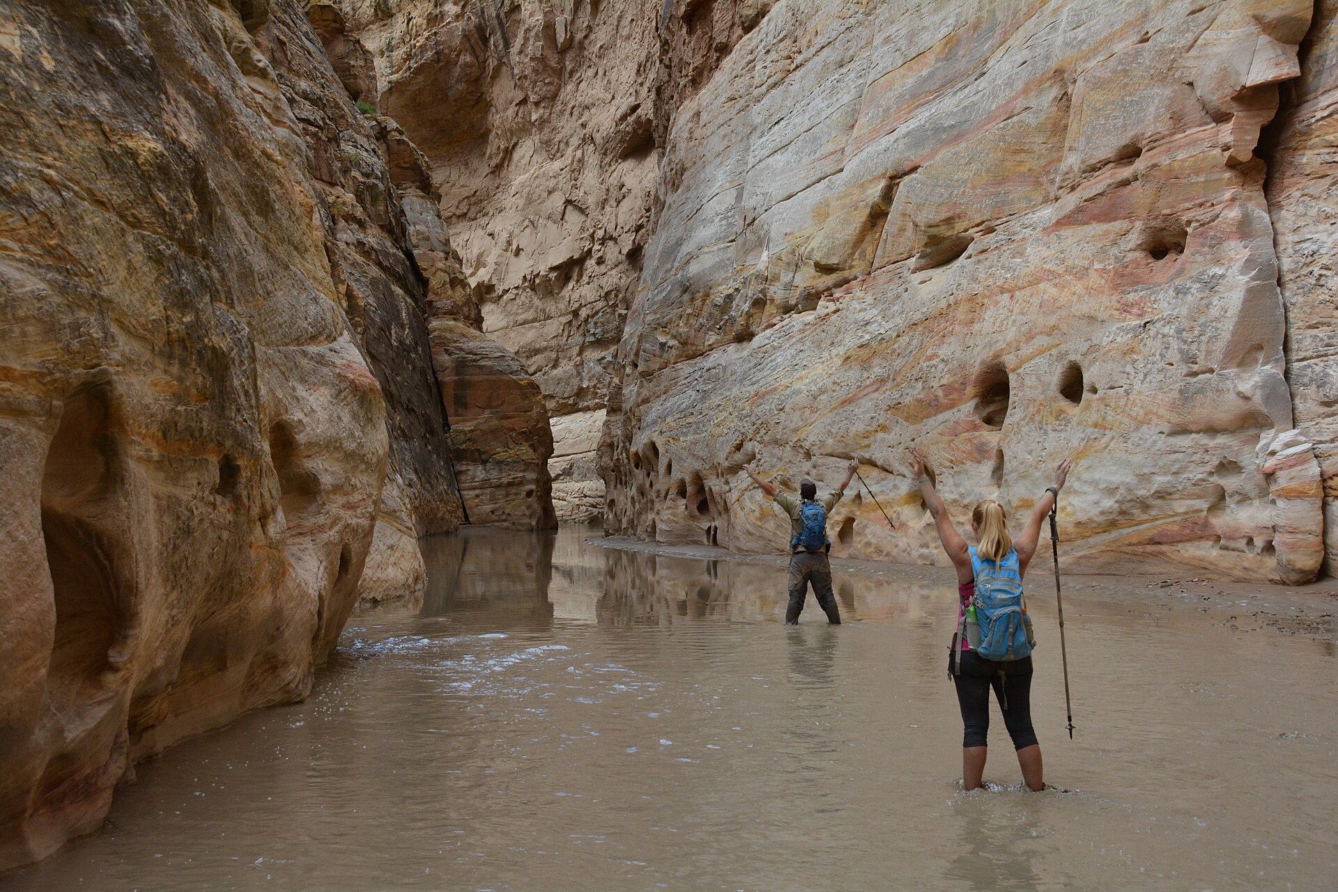 Two canyoneers wading a flooded slot canyon