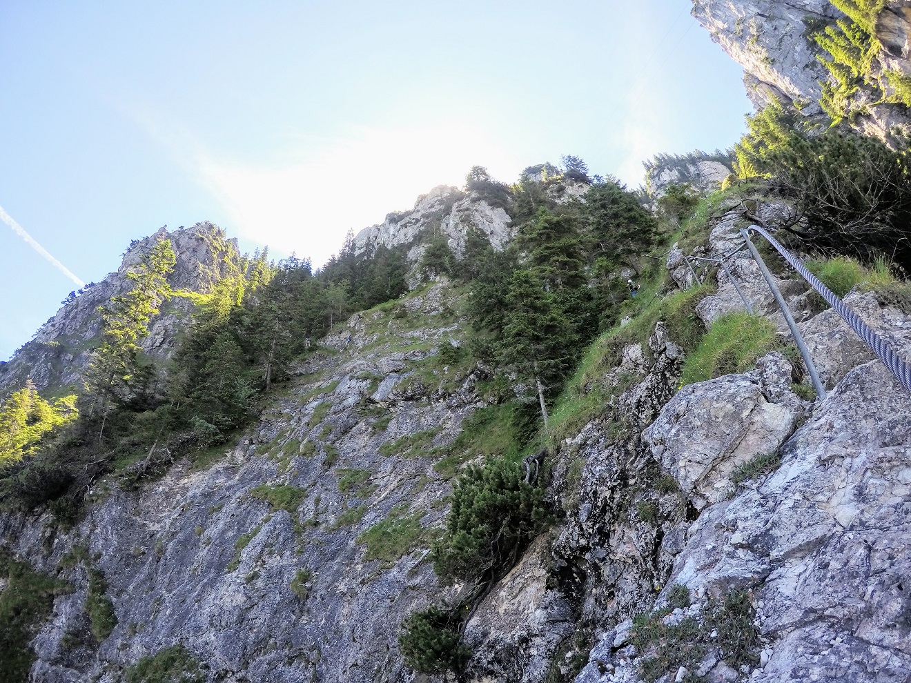 A climber clipped to via ferrata cables